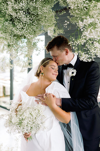 a couple kissing under a tree of flowers